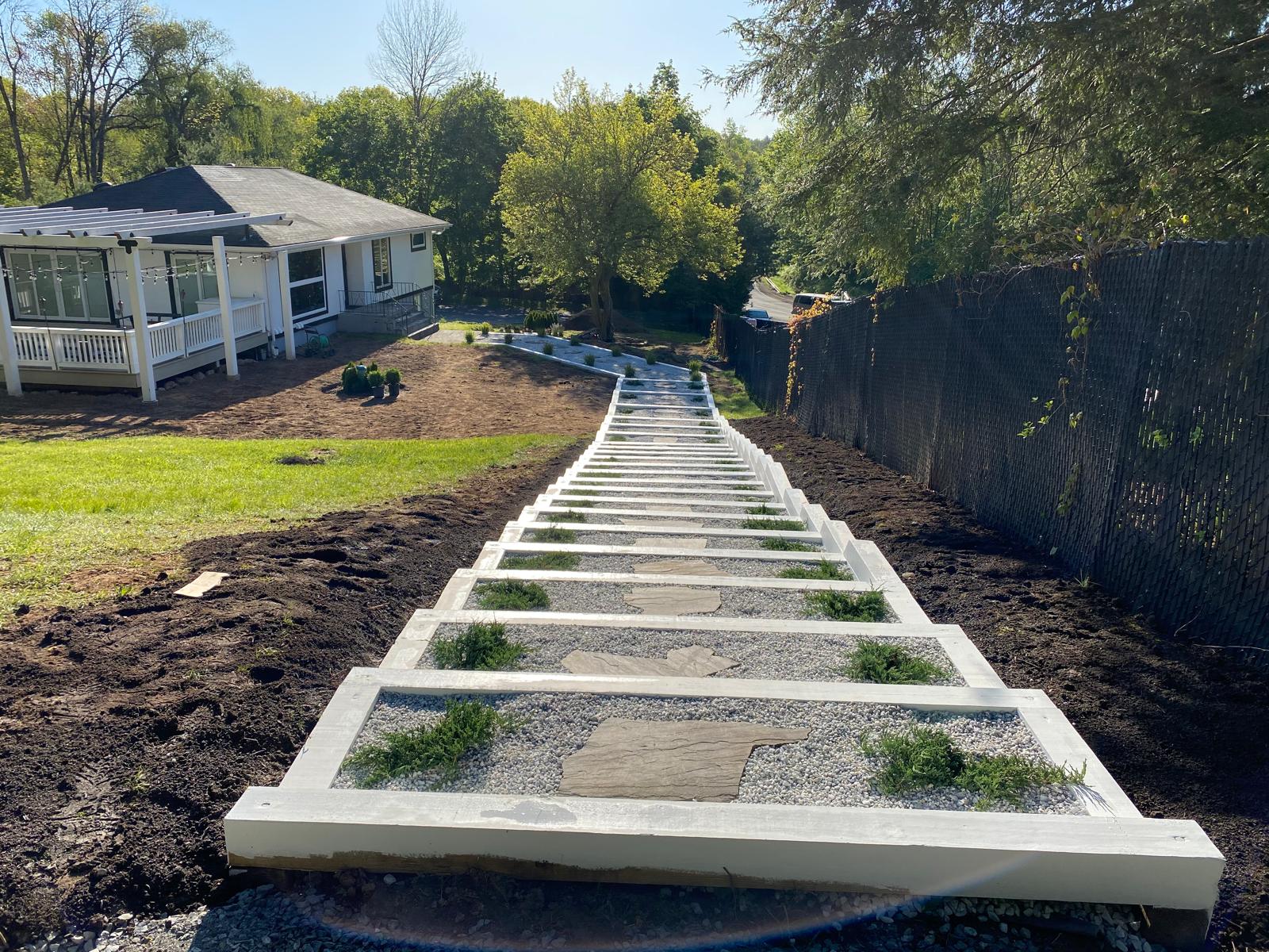 Long walkway with concrete border and gravel under construction